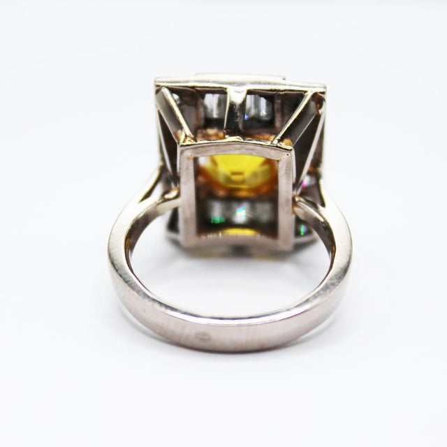 A very rare yellow sapphire and diamond ring in platinum, set with a step cut yellow sapphire of 4.05 carats, within a...