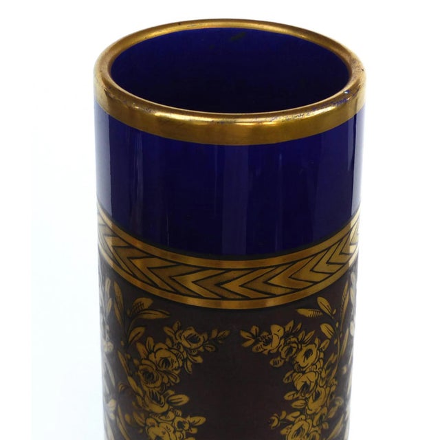 Offered for sale is a striking pair of overscale cobalt blue handled Sevres porcelain urn vases with gilt accents. The...