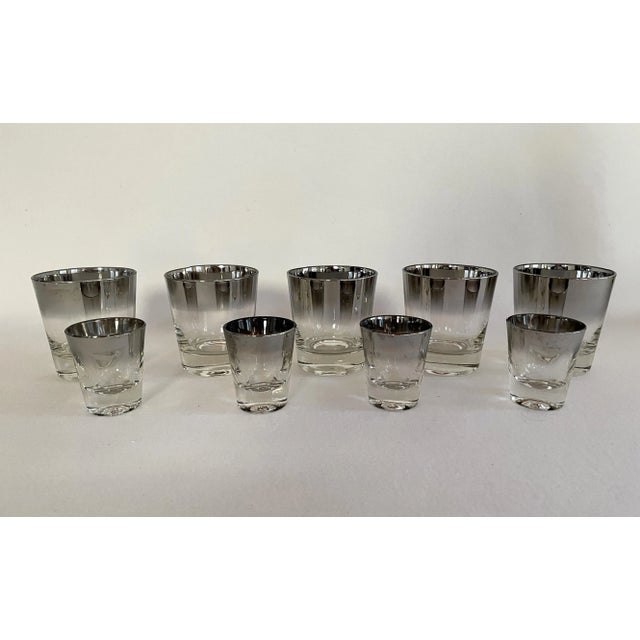 A set of 8 Dorothy Thorpe cocktail glasses. The silver rim glasses includes 4 low ball glasses and 4 shot glasses, perfect...