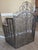 The free standing trifold screen has hinged sides. The heavy metal mesh features an arched top. The front of the screen...