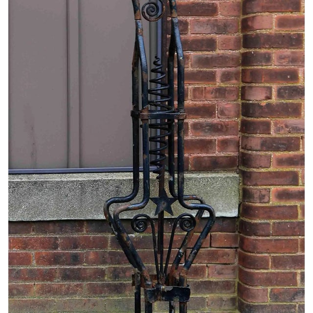 Antique early 20th century ornamental wrought iron arched garden entryway on cast stone blocks. Restoration included.