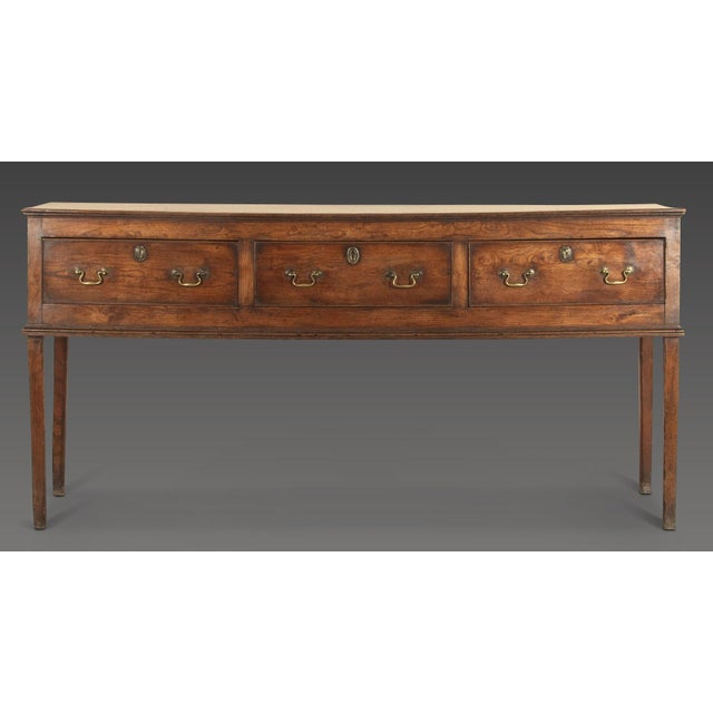 A well desired 18th century elm dresser of elegant proportions. the well figured top above three drawers with original...
