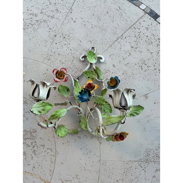 Pair of charming Italian tole candle sconces by Salvadori Firenze feature hand‑painted metal flowers, scrolling arms, and...
