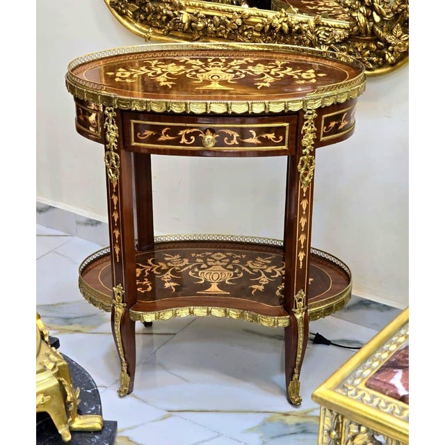 A stunning French Louis XV-style oval side table showcasing exceptional marquetry craftsmanship, elegant proportions, and...