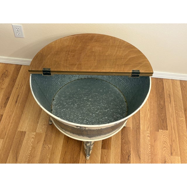 This steel vintage painted washtub from the 1940's has been converted to a coffee table with storage! The lid on one half...