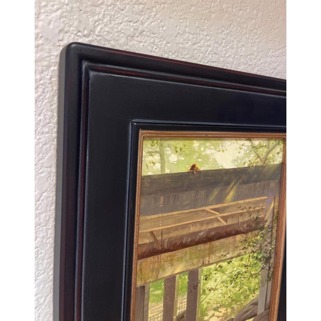This oil on panel depicts a serene scene beneath a weathered bridge, where soft light filters through the foliage,...