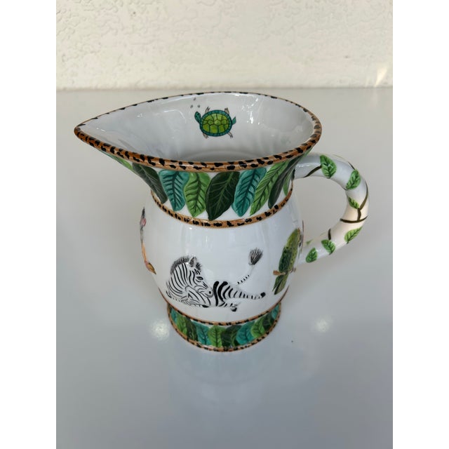 This piece is part of the Jungle Jubilee collection by Lynn Chase. Adorable ceramic pitcher with Chase’s signature jungle...
