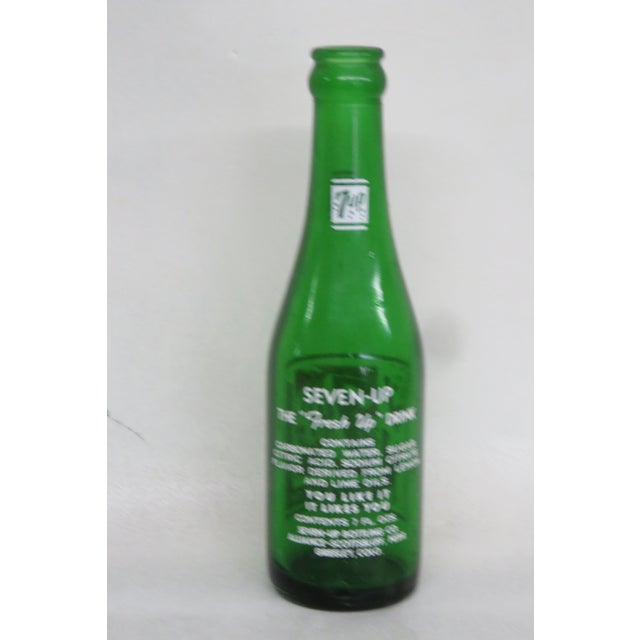 This 7up bottle made out of glass. This empty glass bottle features the swim suited “bubble girl”. Among the lettering on...