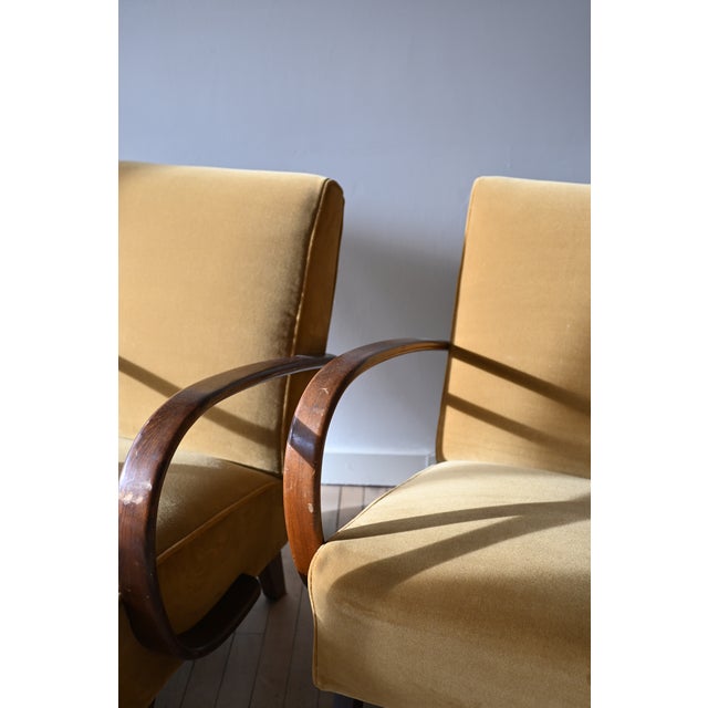 Iconic Halabala armchairs by Czech designer Jindrich Halabala. Curved oak arms are rich with patina. Tall seat backs and...