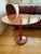 Red travertine side table with lacquered red metal foot