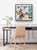 This artwork depicts a vibrant corner shop, filled with colorful flowers that burst with red and blue hues, creating a...