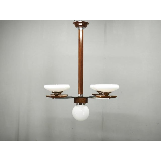 Impressive art deco chandelier made in czechoslovakia in the 1930s, featuring an elegant combination of walnut, chrome-...