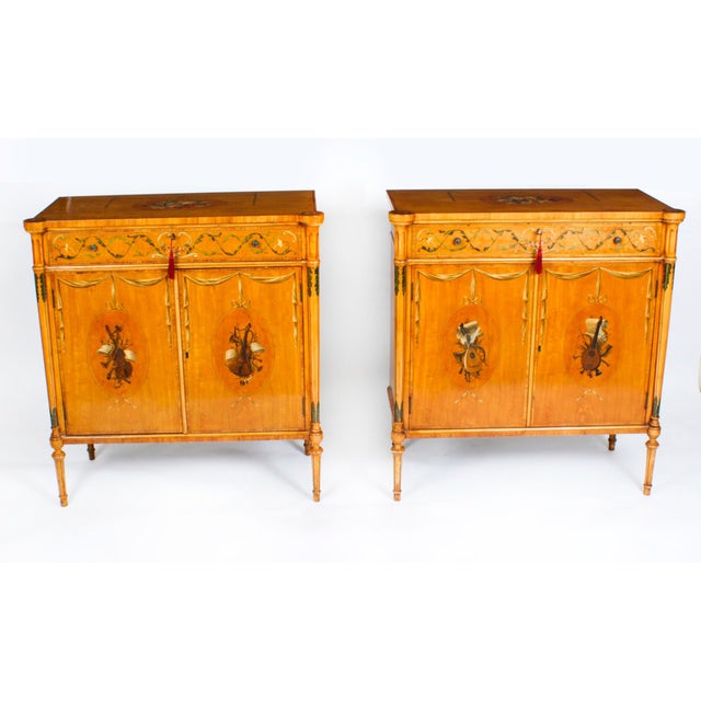 This is a gorgeous antique pair of Adam Revival two door satinwood side cabinets with beautiful hand painted floral...
