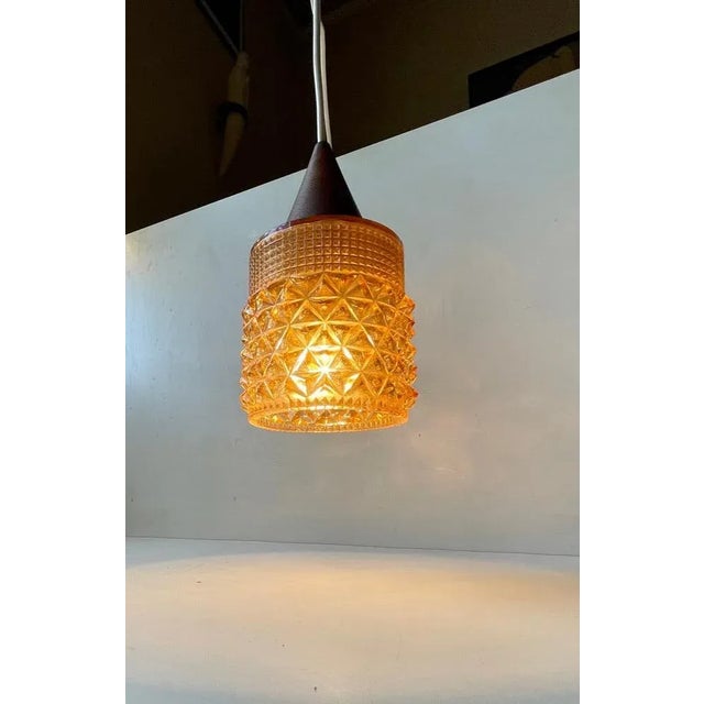 Small Scandinavian hanging light composed of pressed honey glass in diamond pattern glass and a top in solid teak. Unknown...