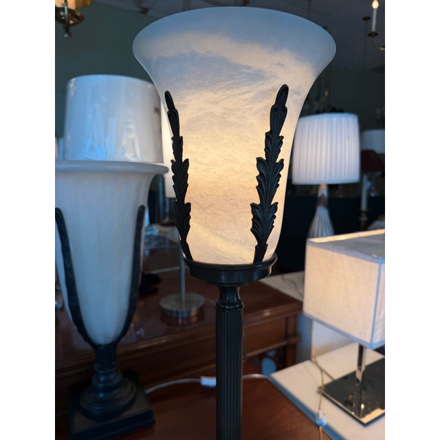 A Haig table lamp featuring a carved alabaster urn supported by decorative bronze leaf-form accents and a fluted column...
