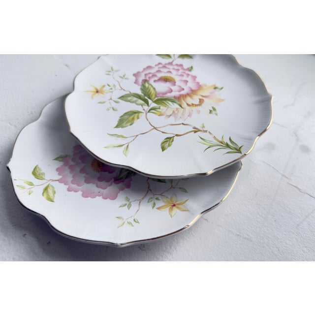 Mid-20th-century Japanese export porcelain plates, marked “Japan,” featuring the “Peony” or “Victorian Rose” pattern. The...