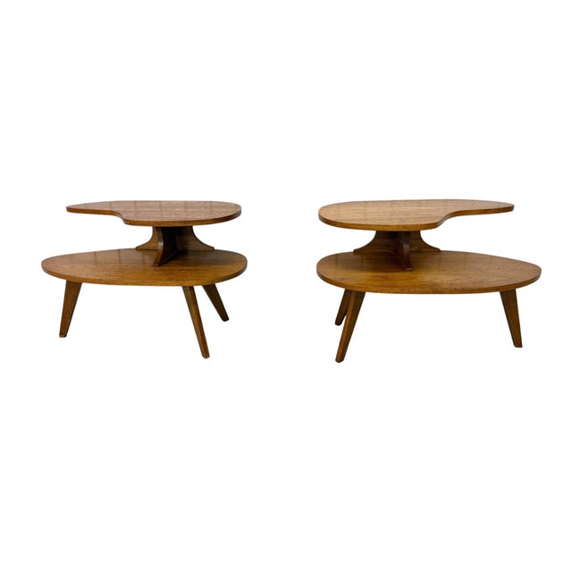 Elevate your living space with this striking pair of mid-century modern walnut side tables, showcasing an eye-catching...