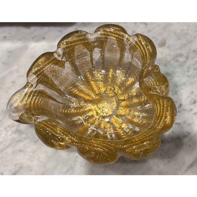 A beautiful piece of art glass attributed to Murano. Gold coloring over a ribbed glass and lots of beautiful flecking make...