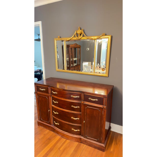 This antique mahogany buffet is a striking piece of furniture that blends functionality with elegance. It features...
