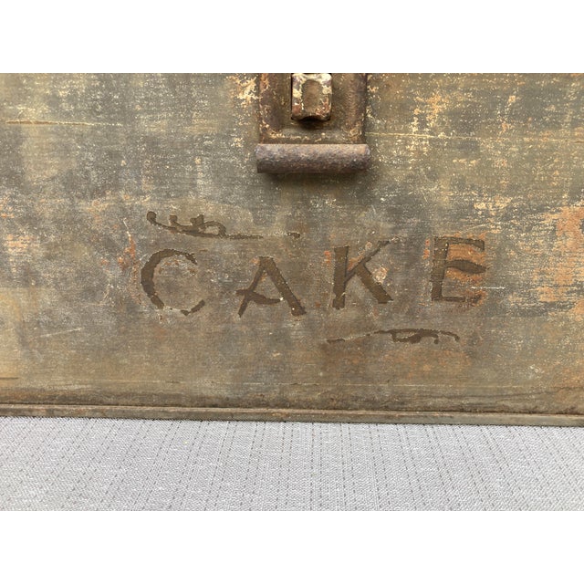 Antique metal cake box with a hinged top, side handles and latch on the front. "CAKE" written along the lower front. Great...
