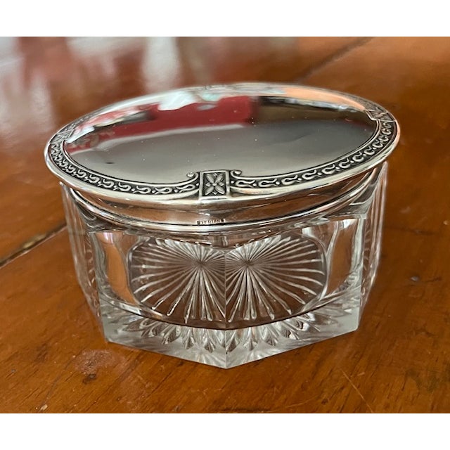 4 1/2" round early 20th century glass powder jar with sterling silver lid. The lid has an embossed pattern circling the...