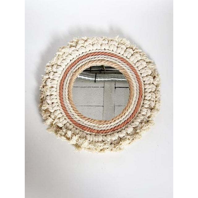 Decorative round wall mirror made in France in the 21st century. The circular mirror is surrounded by an elaborate textile...