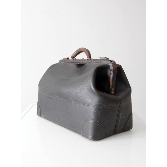 This antique early 20th century doctor’s bag carries the classic Gladstone silhouette with a wide steel frame opening,...