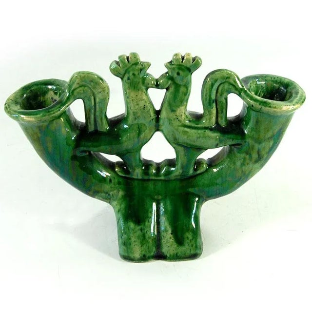 This decorative table candlestick is made of ceramic. It is adorned with a decorative bird motif and finished with a...
