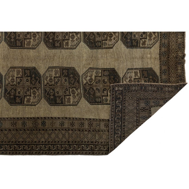 Elevate your space with the understated grandeur of this Antique Turkaman (Turkmen) hand-knotted wool rug. Showcasing a...
