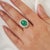 This striking silver ring features a vivid oval cabochon emerald weighing approximately 8.8 carats total weight,...