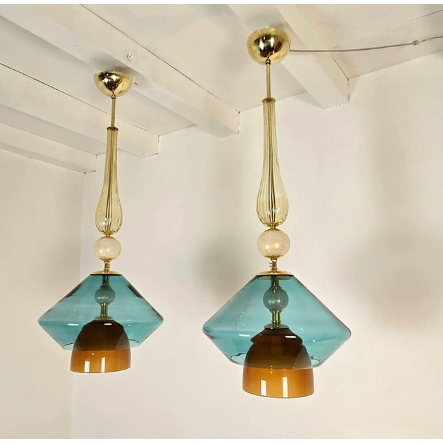Pair of Murano glass Mid-Century Modern pendant lights, Italy circa 2000s. The Italian chandeliers are made of gold,...