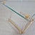 Elegant side table crafted from glass, brass-plated metal, and decorative acrylic elements. The combination of luxurious...