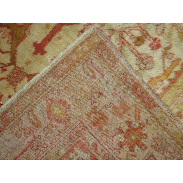 An early 20th century angora wool Oushak rug with a ivory colored field with other subtle warm accents. This is a genuine...