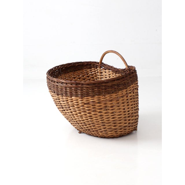 Vintage large handwoven wicker gathering basket featuring a beautiful two-tone weave, sturdy bentwood handle, and raised...