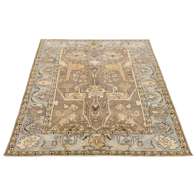 Discover the elegance of this modern Oushak Style hand-knotted wool rug, showcasing a warm light brown field beautifully...