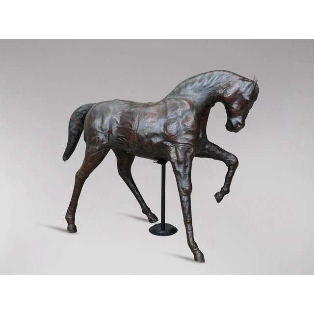 This impressive leather-covered horse sculpture, attributed to Liberty & Co of London circa 1930s, showcases exquisite...