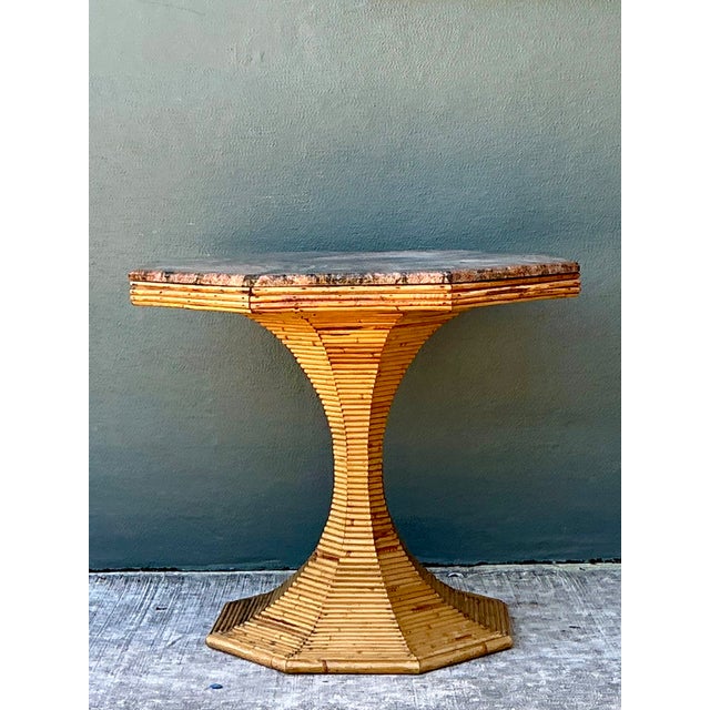 This vintage sculptural table brings together an octagonal stone top and a flared pencil reed base, a pairing rooted in...