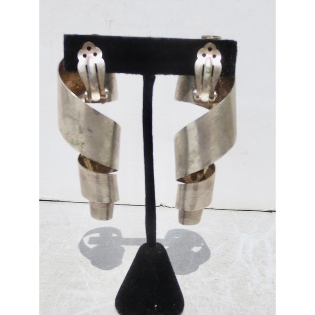 Large metal, curled metal clip-on earrings. Brushed silver-plated brass, Large and striking statements. The measurements...