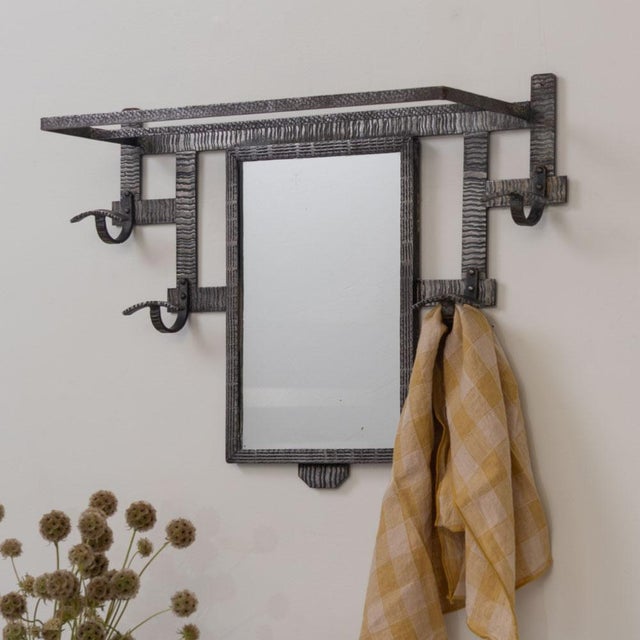 Stunning Art Deco iron wall rack with mirror from France, 1930s. Hammered wrought iron frame with upper rack and 4 iron...