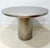 A striking architectural pedestal table crafted in brushed stainless steel, featuring a substantial round top supported by...