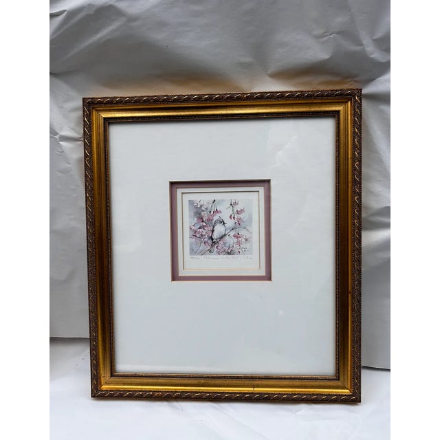 A pair of signed and numbered lithographs by S. Riva of playful birds in soft pastels. Framed in antique gold with cream...