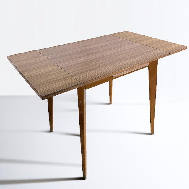 This vintage extending dining table offers a perfect blend of style and functionality for mid-century modern furniture...