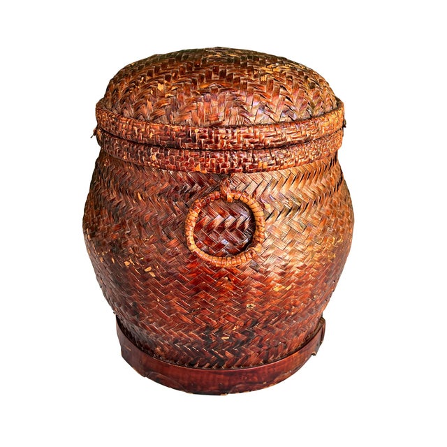 An exceptional handwoven Southeast Asian storage basket featuring richly lacquered rattan or bamboo construction,...