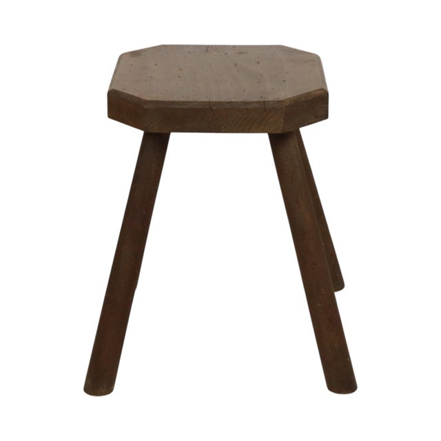 Old wooden stool, milking stool, made of solid wood; this is a rustic and brutalist handmade object from around the...