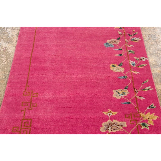 Hand-knotted in wool, this 3x12 contemporary Chinese Deco runner presents an open magenta field detailed with delicate...