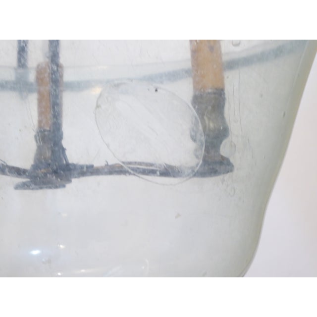 This light is made from an antique blown glass cloche with an iron hanger made to create a hanging fixture. It uses three...