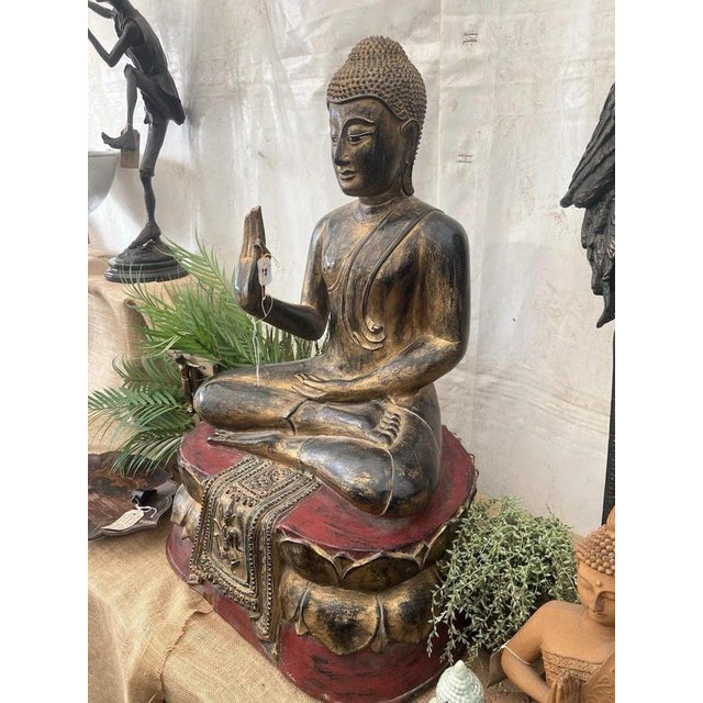 An impressive large-scale hand-carved wooden Buddha figure originating from Thailand and dating to the early 20th century....