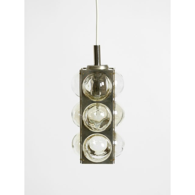 Beautiful mid-century modern "space age" metal and glass pendant lamp by temde. Made in switzerland. the shade features...