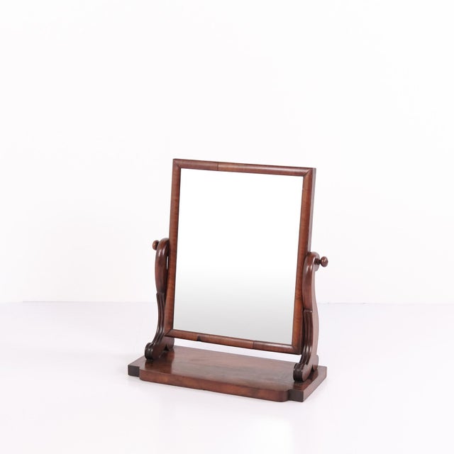 Table mirror crafted in mahogany dating from the 19th century. The mirror features an adjustable glass and reflects the...