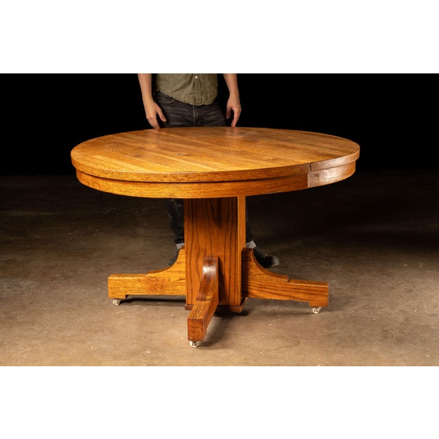 Vintage circular oak dining table. This piece features sturdy, simple construction with minimal ornamentation. The surface...